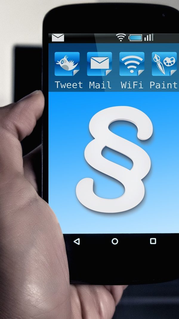 网维大师 App 首页总览界面，深色背景上排列着在线终端数量与告警提示卡片，屏幕在夜间值班室的暗光里微微发亮